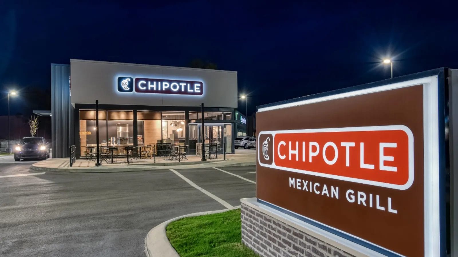 Aerial view of a recently sold Chipotle restaurant building in Christiansburg, prominently featuring the logo, with a surrounding parking lot in a suburban area.