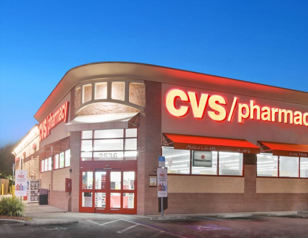 Exterior view of a CVS Pharmacy store in Lakeland, Florida at dusk, featuring illuminated red signage and a clear sky.