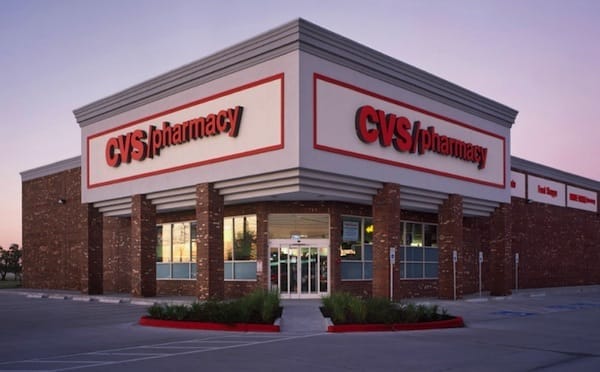 Exterior view of a recently sold CVS Pharmacy store in Springfield, OH at dusk, featuring prominent signage and brick walls.