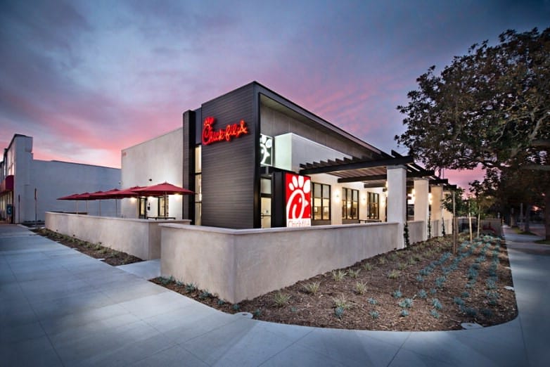 Exterior of a Chick-fil-A restaurant at twilight, featuring modern architecture with distinctive red accents and landscaping, ideal for considering in a 1031 Exchange.