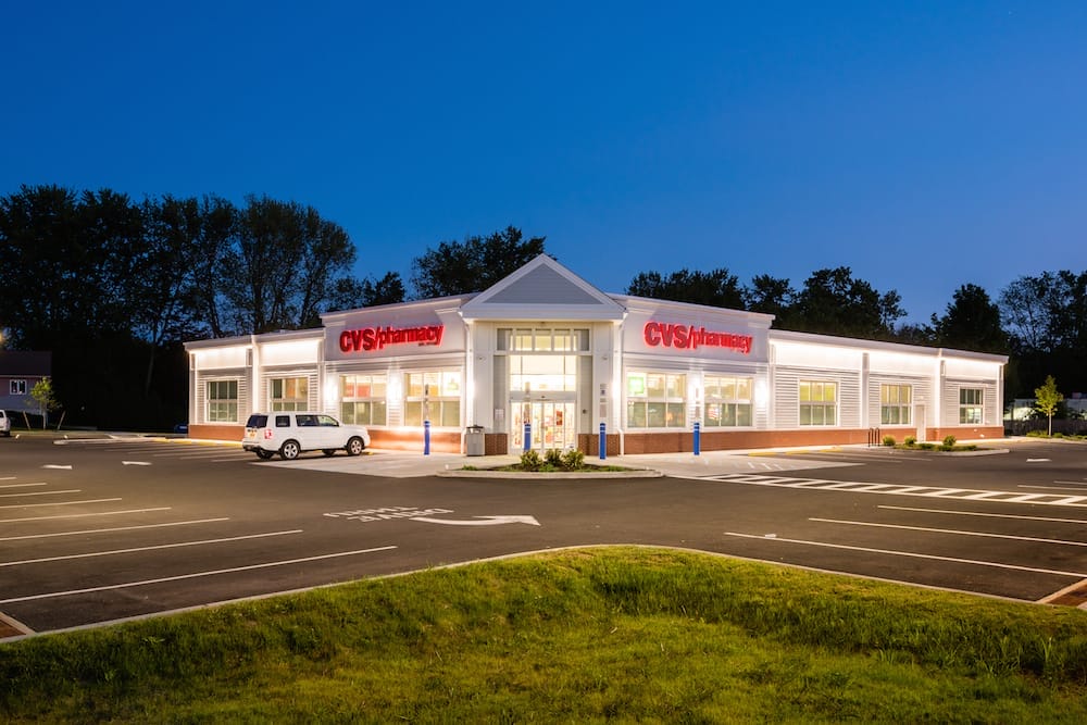 A CVS Pharmacy store brightly lit at night with a clear sky, situated in a nearly empty parking lot, potentially eligible for a 1031 Exchange.
