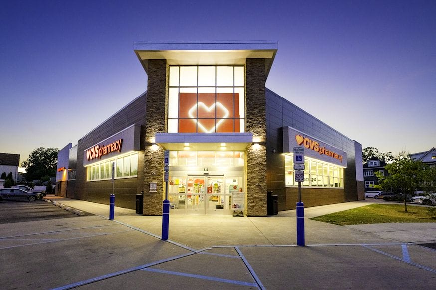Exterior view of a CVS Pharmacy store during twilight, featuring illuminated signage and clear sky, perfect for inclusion in market portfolios.