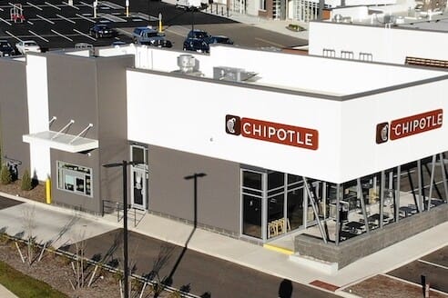 Aerial view of a recently sold Chipotle restaurant building in Christiansburg, prominently featuring the logo, with a surrounding parking lot in a suburban area.