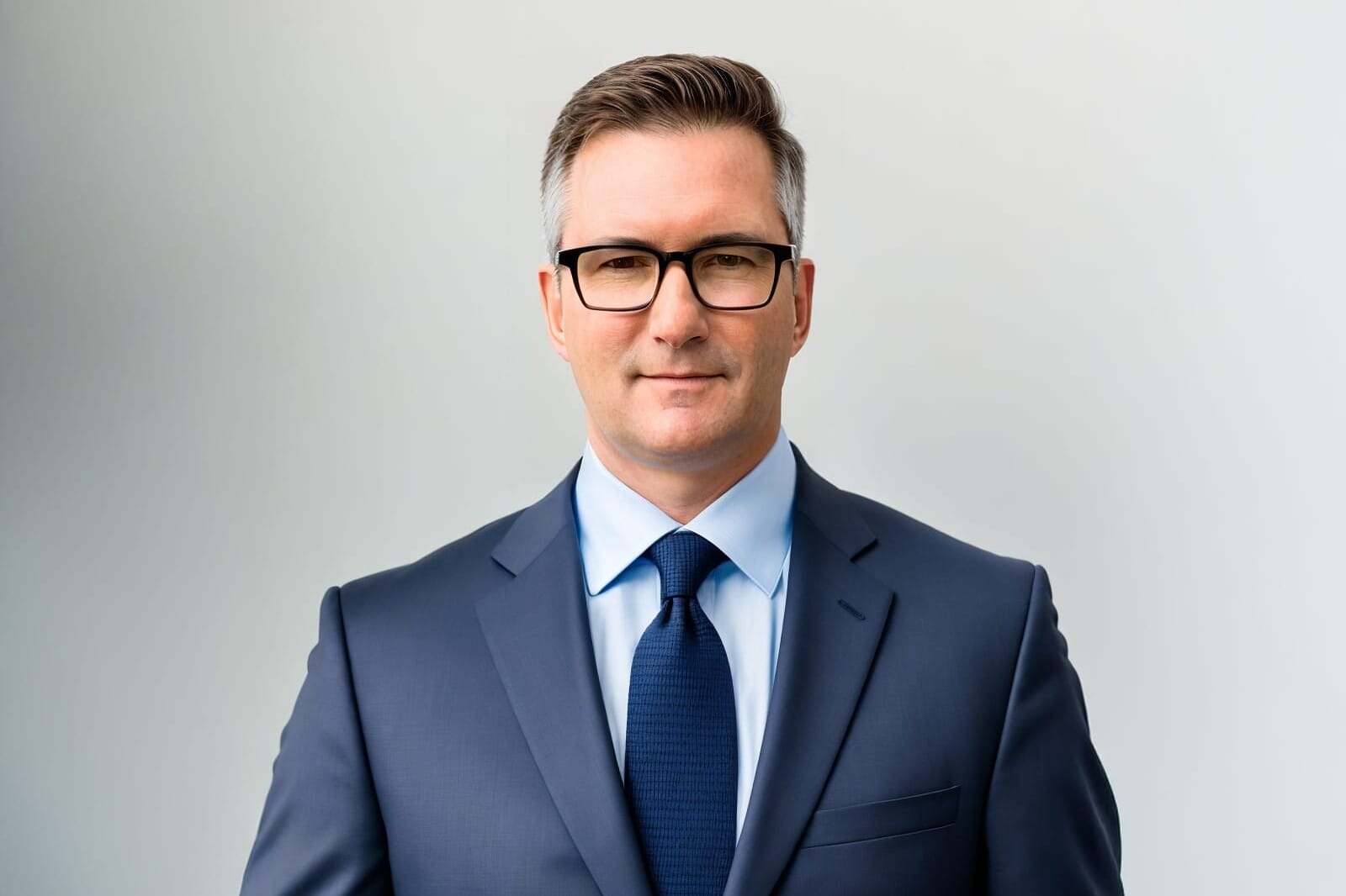 John Spengler posing for profile picture in suit and glasses