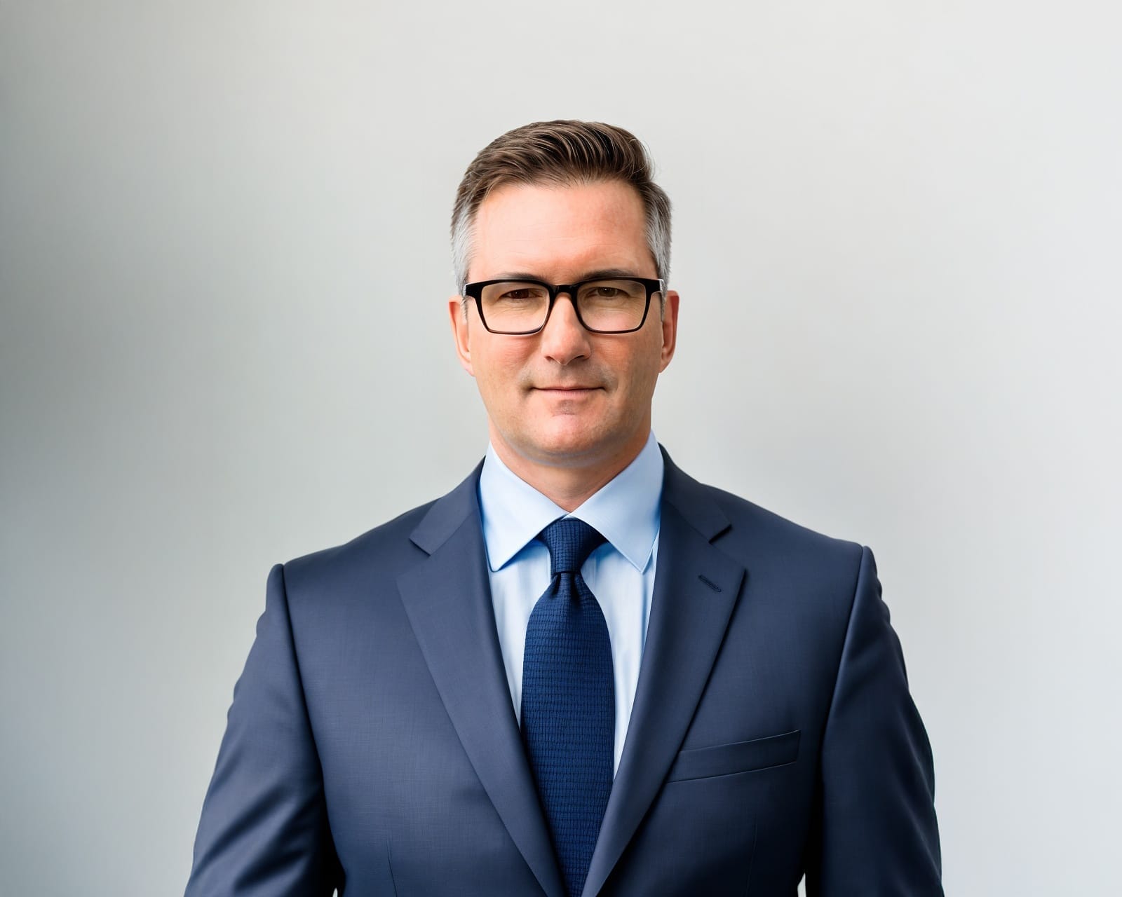 John Spengler posing for profile picture in suit and glasses